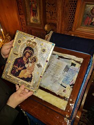 The Holy Icon rests on a bed of cotton, photos and commemoration slips.